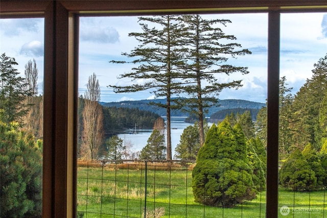 view of water feature featuring fence and a view of trees
