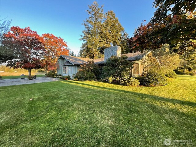exterior space with a chimney and a front lawn