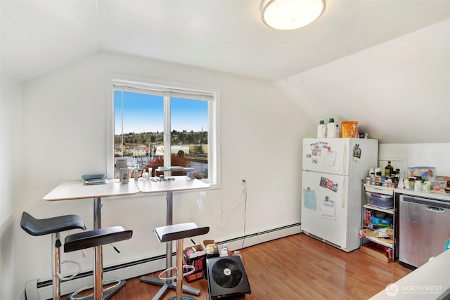 dining space featuring light wood-type flooring, a baseboard heating unit, and lofted ceiling