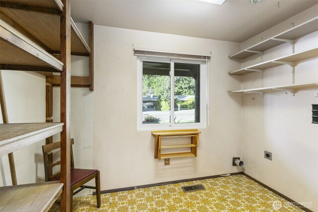 laundry area with visible vents, electric dryer hookup, laundry area, baseboards, and tile patterned floors