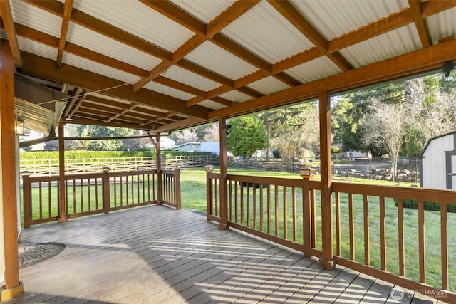 wooden deck featuring fence, a lawn, and an outdoor structure