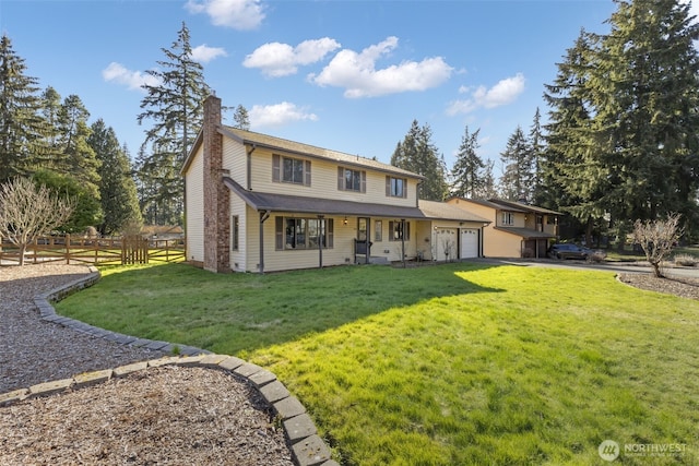 view of front of home with an attached garage, fence, driveway, a chimney, and a front yard