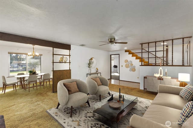 living room with visible vents, a textured ceiling, and ceiling fan with notable chandelier