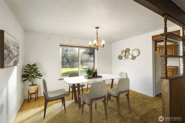 dining room with light carpet, a textured ceiling, and a notable chandelier