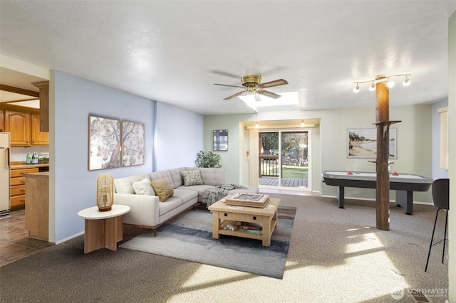 carpeted living room featuring a ceiling fan and baseboards