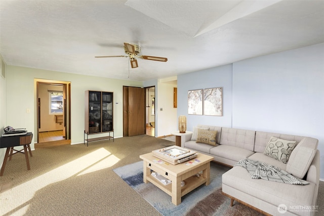 carpeted living room featuring ceiling fan and baseboards