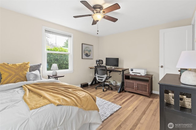 bedroom featuring ceiling fan, light wood-style flooring, and baseboards