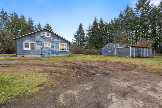 rear view of house with a garage and an outdoor structure