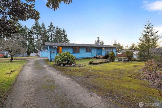 single story home with driveway and a front lawn