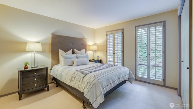 carpeted bedroom featuring access to exterior, multiple windows, and baseboards