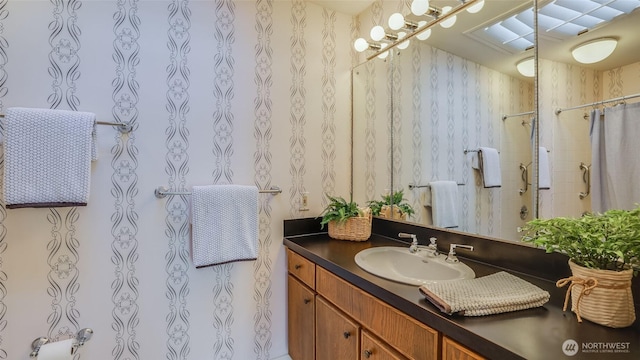 bathroom with wallpapered walls, vanity, and a shower with curtain