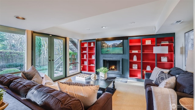 living room featuring french doors, a fireplace, and visible vents