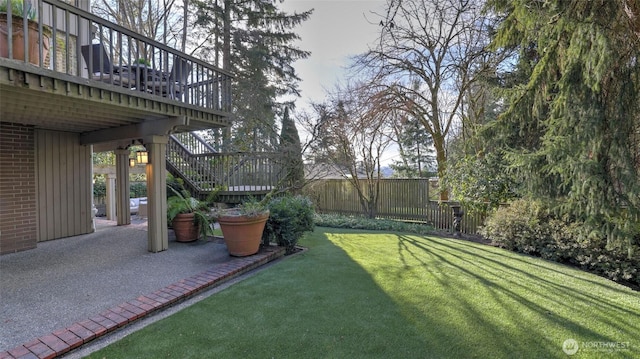 view of yard with fence, stairway, a wooden deck, and a patio