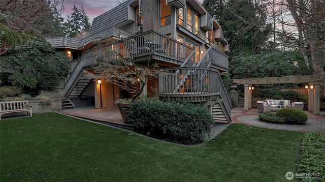 back of house featuring stairs, a patio area, a yard, and an outdoor hangout area