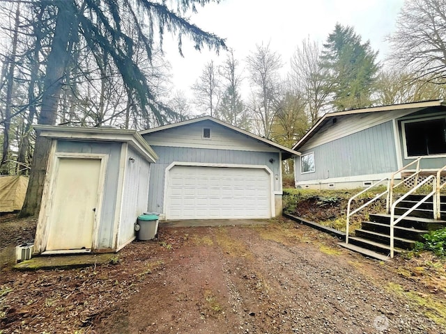 garage featuring dirt driveway