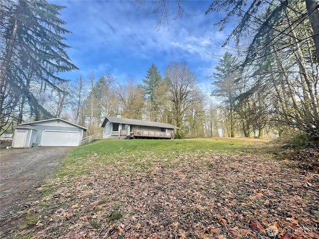 view of front of property featuring a garage, a front yard, and an outbuilding