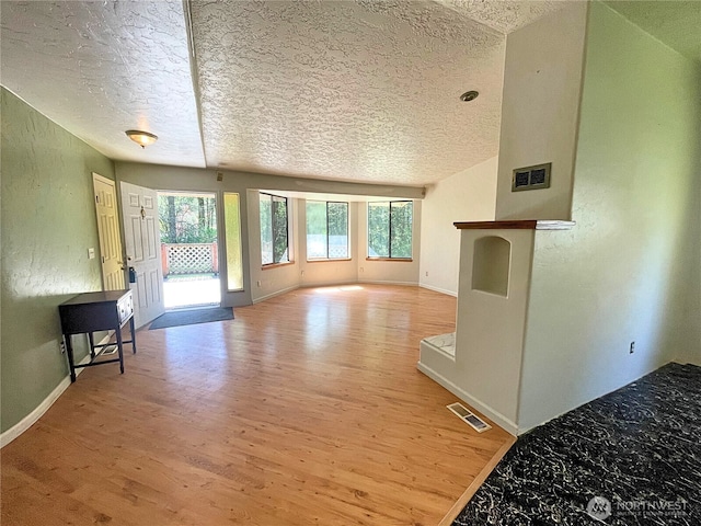 7116 Comanche Ln SW, Olympia, WA 98512 - unfurnished living room featuring baseboards, wood finished floors, visible vents, and a textured ceiling