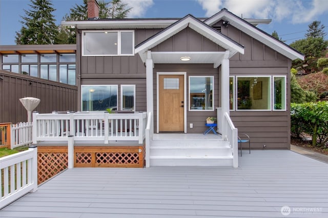 exterior space featuring a chimney, board and batten siding, and a wooden deck