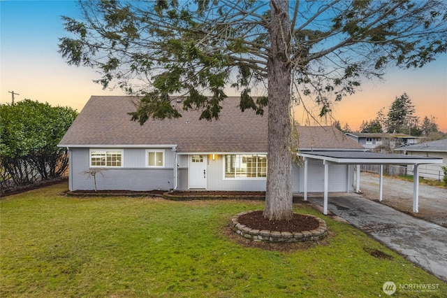 view of front of house featuring driveway, an attached garage, a front lawn, and roof with shingles