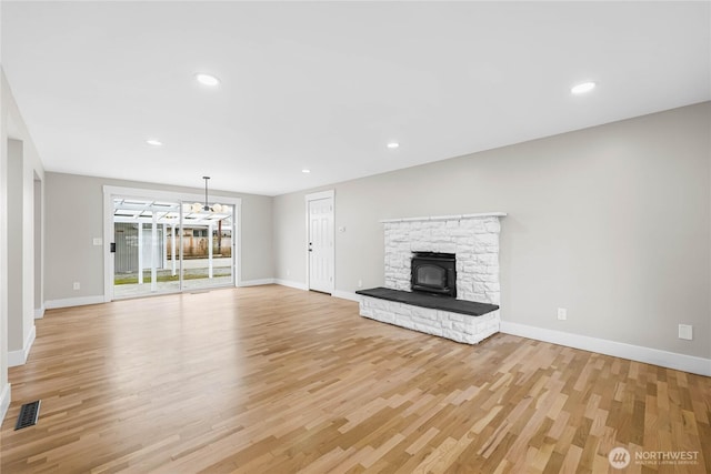 unfurnished living room featuring light wood finished floors, visible vents, and baseboards