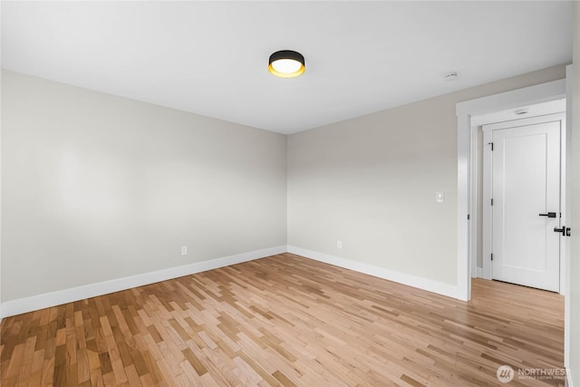 empty room with light wood-type flooring and baseboards