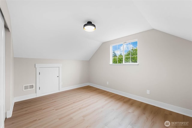 bonus room featuring vaulted ceiling, light wood-type flooring, visible vents, and baseboards