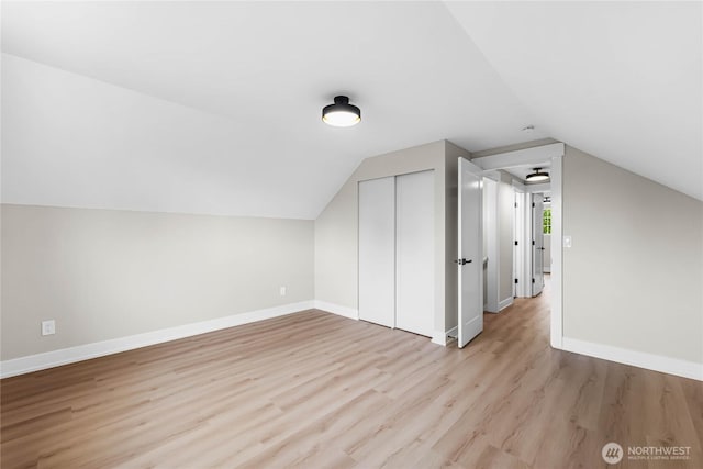 bonus room with lofted ceiling, light wood-style flooring, and baseboards