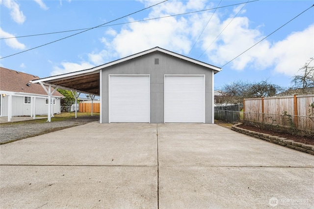 garage with a detached garage and fence