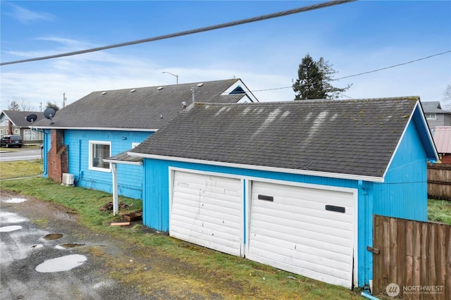 detached garage featuring fence