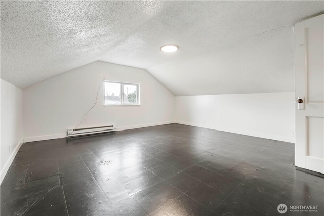 additional living space featuring lofted ceiling, baseboards, baseboard heating, and a textured ceiling