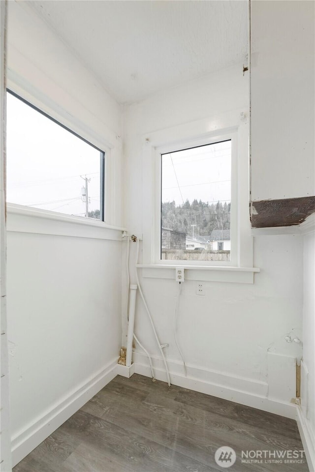 laundry room featuring baseboards and wood finished floors