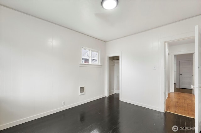 interior space featuring visible vents, dark wood-type flooring, and baseboards