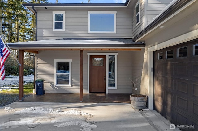 doorway to property with a garage and covered porch