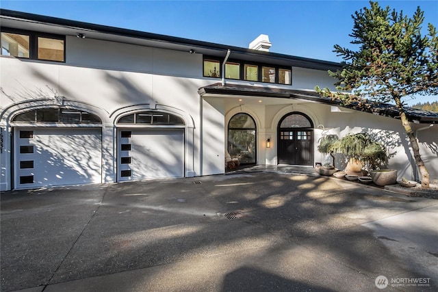 view of front of home featuring a garage, driveway, and stucco siding