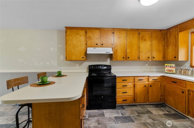 kitchen with under cabinet range hood, light countertops, brown cabinets, a peninsula, and electric range