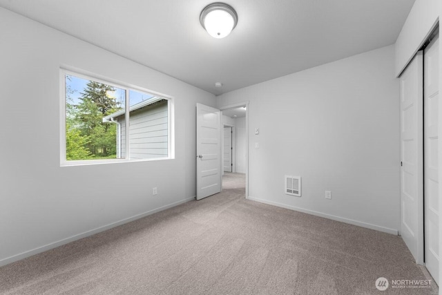 unfurnished bedroom featuring carpet, visible vents, baseboards, and a closet
