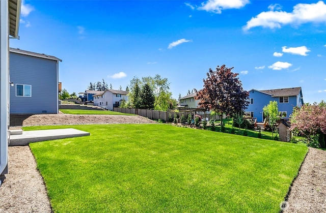 view of yard featuring fence and a residential view