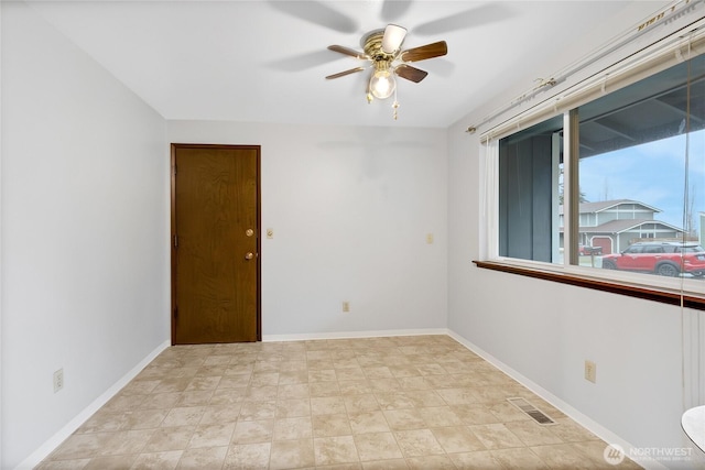 empty room featuring baseboards, visible vents, and a ceiling fan