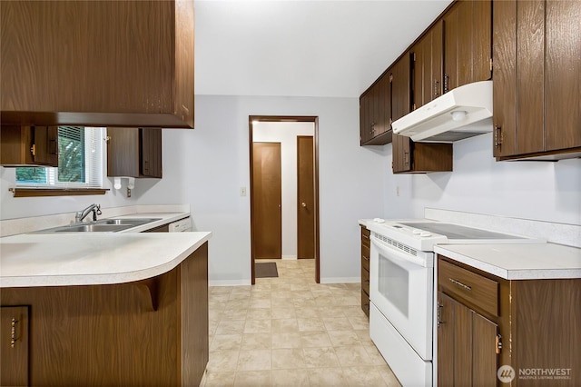 kitchen featuring white electric stove, a breakfast bar area, under cabinet range hood, a sink, and light countertops