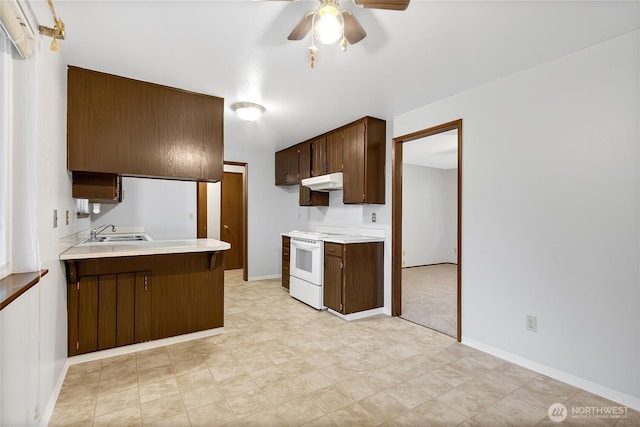 kitchen with light countertops, white range with electric cooktop, a peninsula, and under cabinet range hood