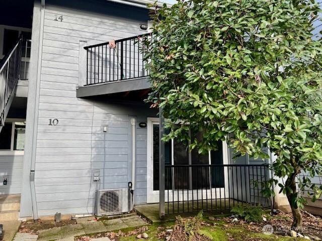 back of house featuring a balcony, ac unit, and fence