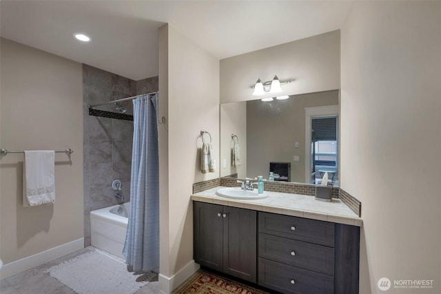 bathroom featuring shower / bath combination with curtain, vanity, and baseboards