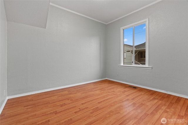 unfurnished room featuring ornamental molding, baseboards, visible vents, and light wood finished floors