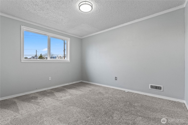 spare room featuring carpet floors, baseboards, visible vents, and ornamental molding