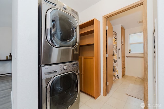 laundry area featuring visible vents and stacked washing maching and dryer