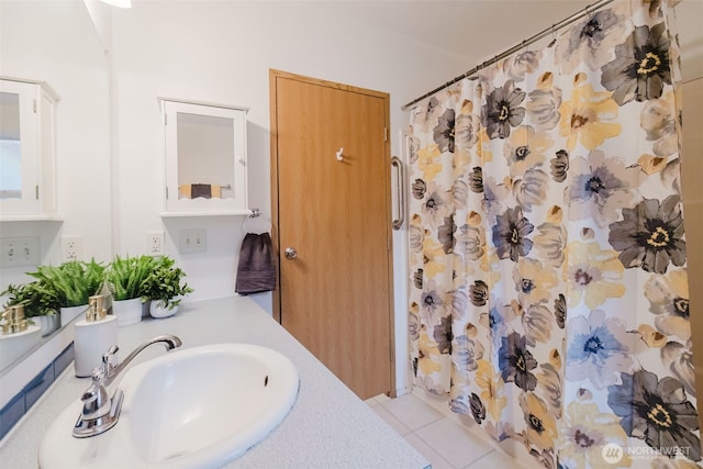 bathroom with a shower with shower curtain, tile patterned flooring, and a sink