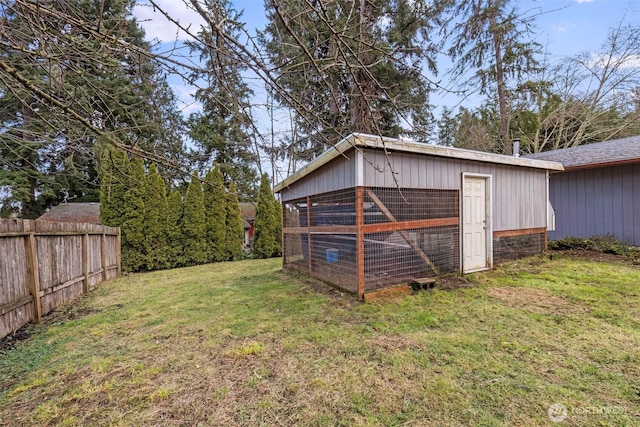 view of yard with fence, exterior structure, and an outdoor structure