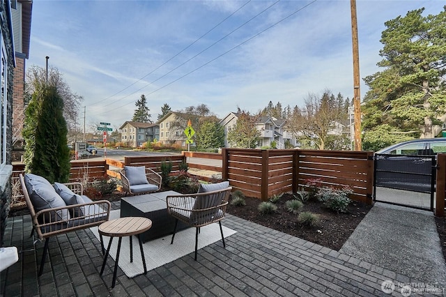 view of patio featuring outdoor lounge area, a gate, and a residential view