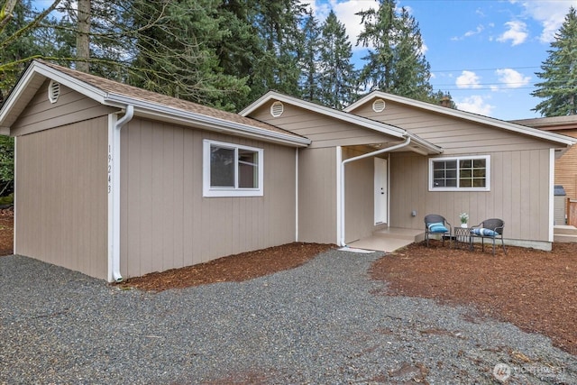 ranch-style house featuring roof with shingles and driveway