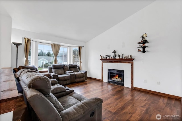 living area featuring dark wood-style floors, a fireplace, baseboards, and vaulted ceiling